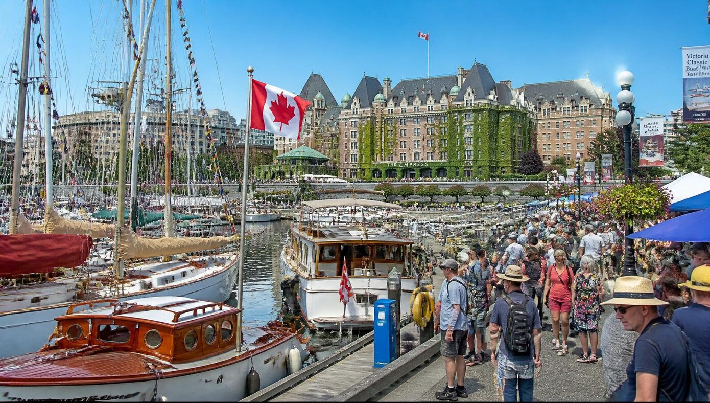 Classic boats on display at the Victoria Inner Harbour boat show, with heritage vessels and the Empress Hotel in the background